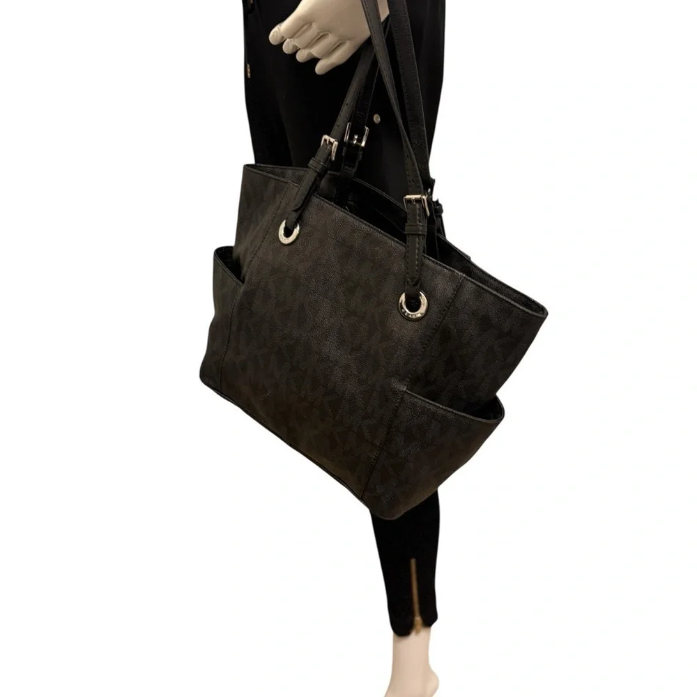 Michael Kors Elegant Black Handbag. Sides packets with a log in the front